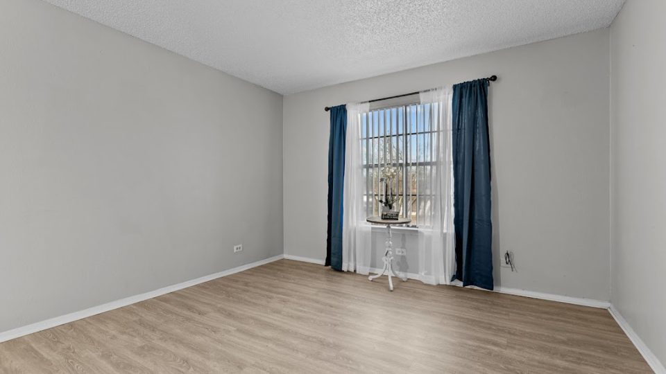 empty room with hardwood floors and windows at The Northwood Apartments