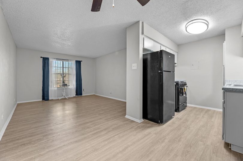 an empty room with a refrigerator and a ceiling fan at The Northwood Apartments