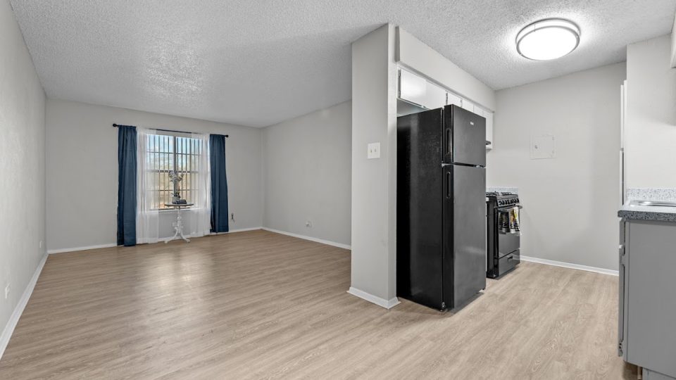 an empty room with a refrigerator and a ceiling fan at The Northwood Apartments