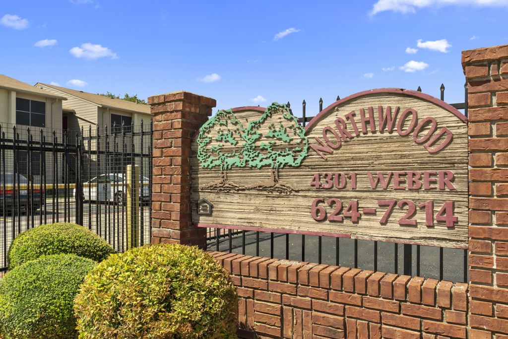 the sign for the entrance to the woodwood apartments at The Northwood Apartments